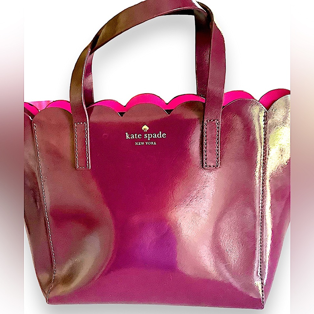 Kate Spade beautiful plum in a vinyl material . In pre owned condition.